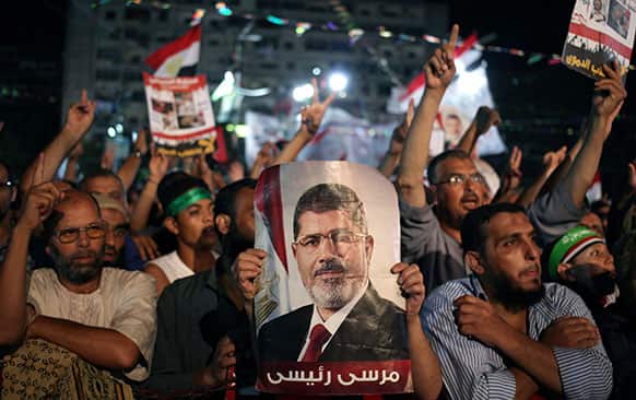 Supporters of Egypt`s ousted President Mohammed Morsi chant slogans one holding a picture of Morsi with Arabic writing that reads: