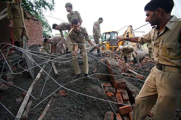 Rescue workers search through the debris of an under construction building, which collapsed on the outskirts of Jammu.