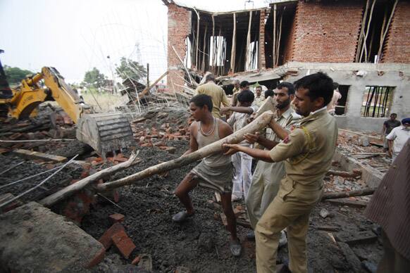 Rescue workers search through the debris of an under construction building, which collapsed on the outskirts of Jammu.