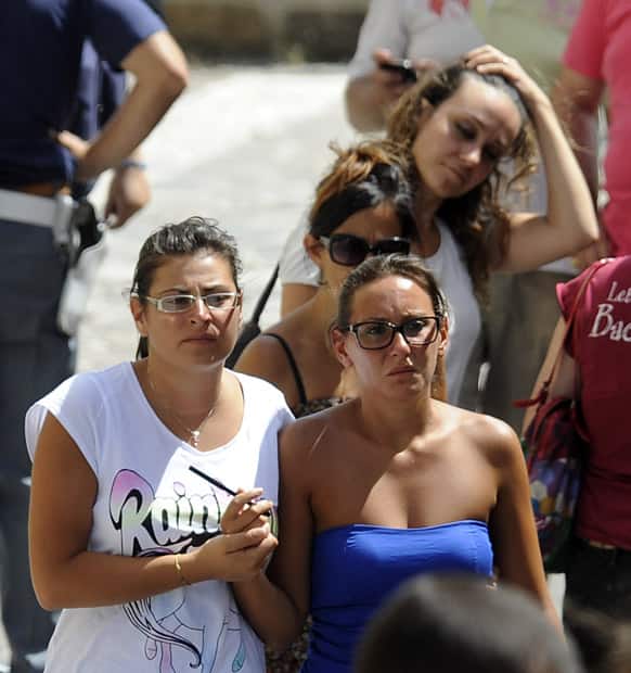 People comfort each other outside a gym facility of an elementary school turned into a morgue, in Monteforte Irpino southern Italy.