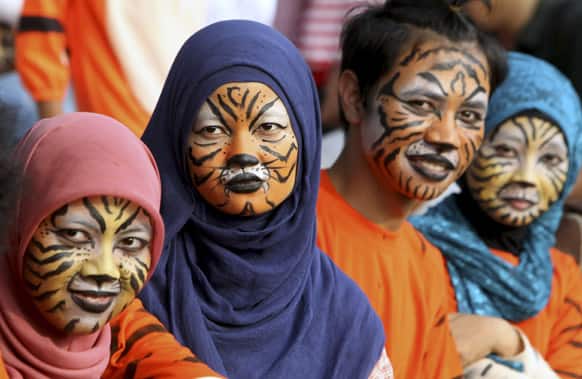 Activists with faces painted to resemble tigers, take part in a protest against Sumatran tiger trade that marks the Global Tiger Day, in Jakarta.