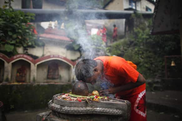 A Nepalese Hindu devotee offers a prayer after collecting water from the Bagmati river during the Bol Bom pilgrimage on the outskirts of Katmandu, Nepal.