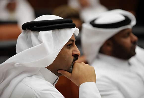Bahraini lawmakers Khaled Abdel A`al, left, and Osama al-Tamimi, right, listen during a special session of parliament to discuss how to handle the uprising in the Gulf island kingdom, convened in Manama, Bahrain.