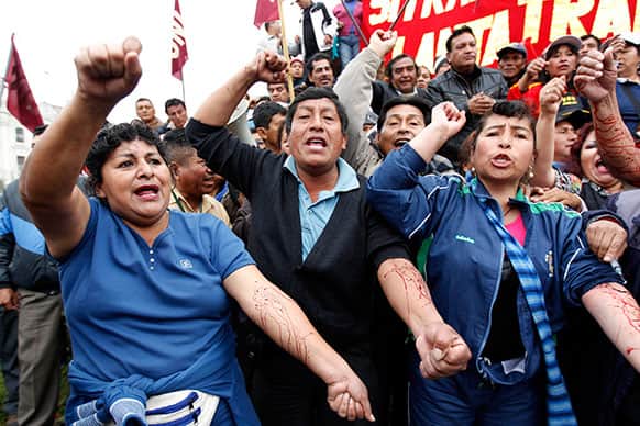 Peruvians shout slogans as they bleed from self-inflicted punctures they made with needles, during an anti-government protest timed to President Ollanta Humala`s State of the Nation address to Congress, in Lima, Peru.