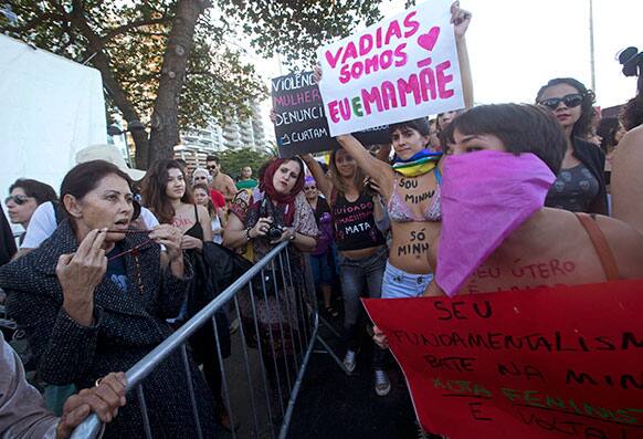 A woman holds a rosary as she speaks to women making a