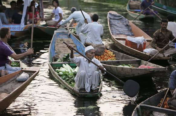 A Kashmiri man paddles his boat loaded with vegetables at the floating vegetable market on Dal Lake in Srinagar.