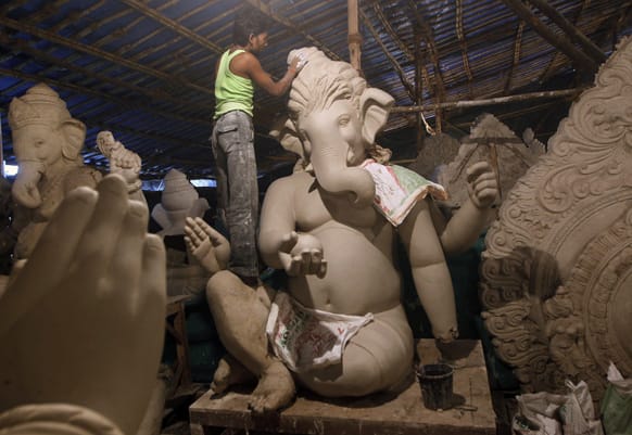 A worker prepares idols of the Hindu God Ganesh for sales for the upcoming Ganesh Chaturthi festival at a workshop in Mumbai.