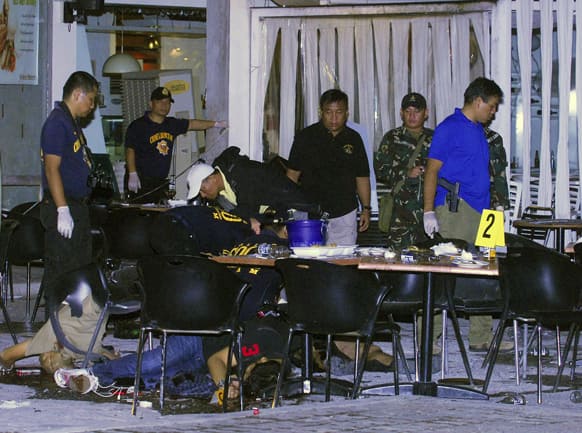 Bodies of victims lay on the floor as police examine the scene of an explosion with the use of an improvised explosive devise (IED) at one of the restaurants at the Lim Ket Kai arcade in Cagayan de Oro City in southern Philippines.