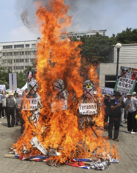 South Korean protesters burn effigies of North Korean leader Kim Jong Un, his late father Kim Jong Il and his late grandfather Kim Il Sung, during a rally marking the 60th anniversary of the signing of the armistice agreement that ended the Korean War on July 27, 1953, in Seoul, South Korea.