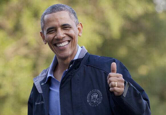 President Barack Obama give the thumbs up as walks from Marine One the the White House, in Washington, as he arrives after spending the day at Camp David with members of his cabinet and their families.