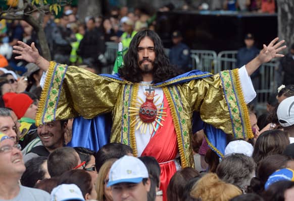 A man dressed as Jesus Christ poses for a photo as he with others for Pope`s Francis` to give Angelus noon prayer at the Sao Joaquim Palace in Rio de Janeiro, Brazil.
