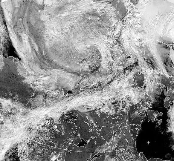 A cyclone, upper center, forms over the Canadian Arctic, seen in an Environment Canada/NOAA satellite image taken at 3:42 p.m. EDT.
