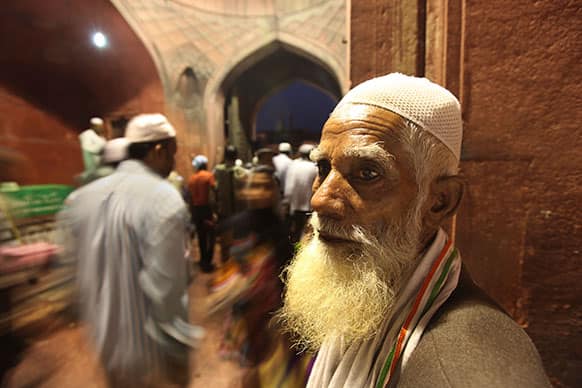 An Indian Muslim man watches as others return after breaking their fast during the holy month of Ramadan at the Jama Mosque in New Delhi.