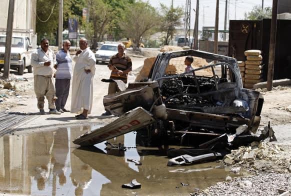 Civilians inspect the aftermath of a car bomb attack in Baghdad, Iraq. A bomb exploded near a Sunni mosque in Baghdad`s southern Dora neighborhood on Tuesday, killing several people and wounding many more, police said.
