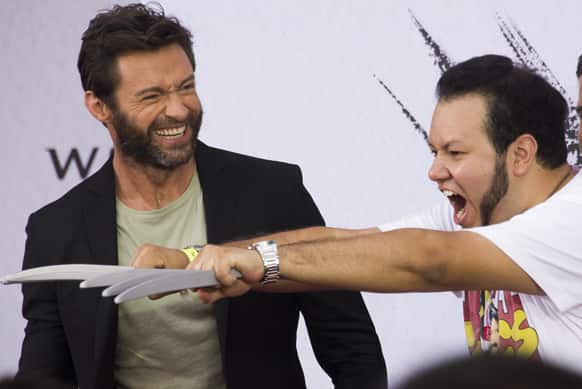 A fan shows Hugh Jackman his Wolverine impression at promotional event for