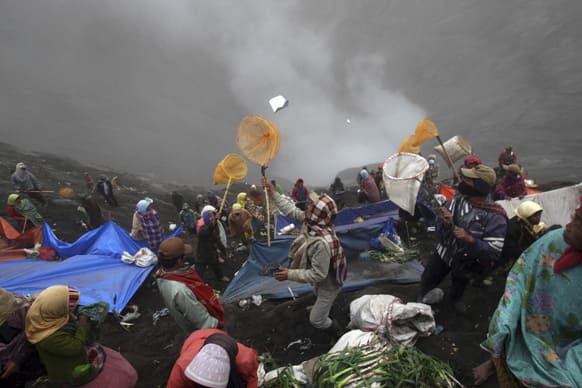 Villagers use nets to catch offerings thrown into the crater of Mount Bromo by Hindu devotees during Yadnya Kasada festival in Probolinggo, East Java, Indonesia.