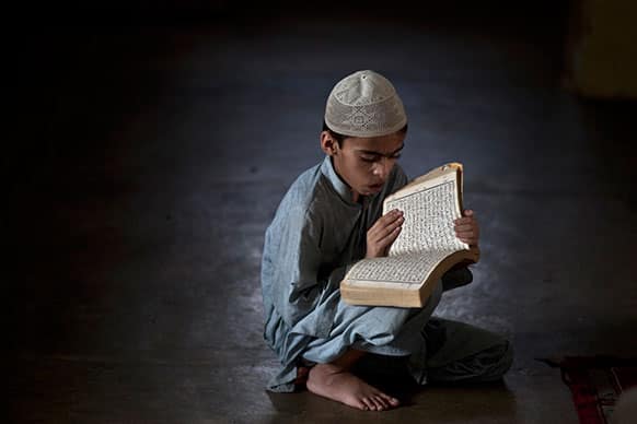 A Pakistani student of a madrassa, or Islamic school, attends a test in reciting verses of the Quran, during the Muslim holy fasting month of Ramadan, in a Mosque in Islamabad, Pakistan.