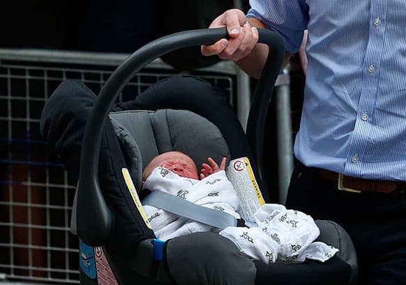 Britain`s Prince William carries his son the Prince of Cambridge into a car outside St. Mary`s Hospital exclusive Lindo Wing in London, where his wife, Kate, the Duchess gave birth on Monday.