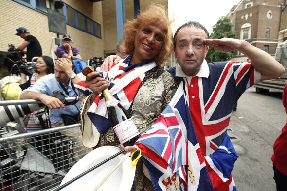 Royal supporters gesture to photographers as they await the departure of Britain`s Prince William, Kate, Duchess of Cambridge and His Royal Highness Prince of Cambridge outside St. Mary`s Hospital exclusive Lindo Wing in London.