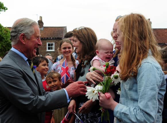Britain`s Prince Charles, the Prince of Wales, with 6 month old Emily Scott, as he meets crowds of well wishers on a visit to Bugthorpe, England.