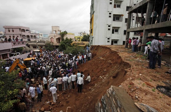 People crowd the site where the wall of a building collapsed in Hyderabad. Six people were killed and two children rescued from the debris when the wall collapsed on two huts, according to news reports.