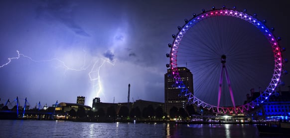 Lightning strikes behind The London Eye in central London which is lighted up in the national colors of red, white and blue to mark the birth of Prince William and his wife Kate`s first child.