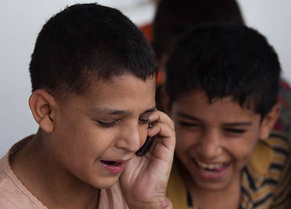 Pakistani runaway boy Naveed Khan talks to his father on the phone while waiting to go to his hometown Peshawar, at Edhi foundation shelter in Islamabad, Pakistan.