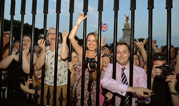 The large waiting crowds cheers as the Queen`s Press Secretary Ailsa Anderson, with Badar Azim, a footman, place on an easel in the forecourt of Buckingham Palace a notification, to announce the birth of a baby boy, at 4.24pm to the Duke and Duchess of Cambridge at St Mary`s Hospital in west London.