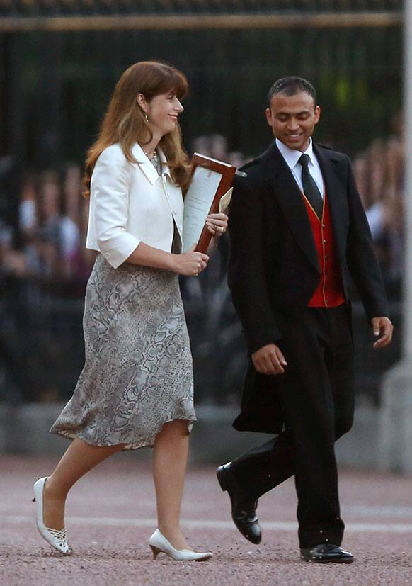 The Queen`s Press Secretary Ailsa Anderson with Badar Azim, a footman, carry out a notice proclaiming the birth of a baby boy to Prince William and Kate, Duchess of Cambridge to put on display for the public view at Buckingham Palace in London.