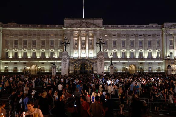People gather outside a floodlit Buckingham Palace in London to mark the birth of a baby boy to Prince William and Kate, Duchess of Cambridge.