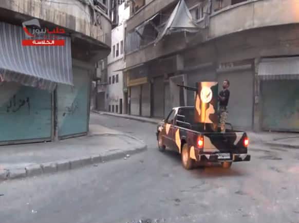 This image taken from video obtained from the Shaam News Network, which has been authenticated based on its contents and other AP reporting, a fighters from the Free Syrian Army targets one of the bastions of the regime’s forces.