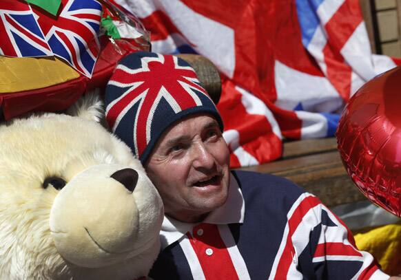 Royal supporter John Loughrey poses with royal baby memorabilia as he waits across the street from St. Mary`s Hospital exclusive Lindo Wing in London.