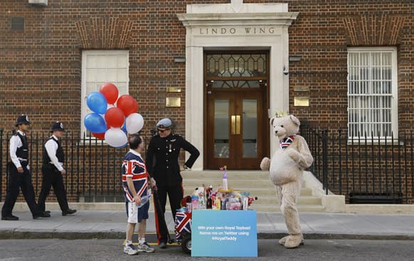 A Prince Harry lookalike talks with a royal supporter as he turns up to donate toys as a publicity stunt outside the Lindo Wing at St Mary`s Hospital in London.