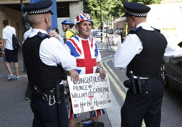 Police officers talks to royal supporter Terry Hutt, center, outside St. Mary`s Hospital Lindo Wing in London as he arrives to stake his place outside the building where Prince William and his wife Kate are expecting their first child to be born in mid-July.