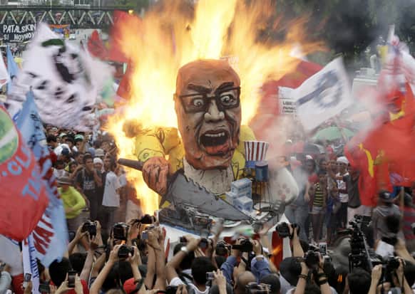 Protesters burn an effigy of Philippine President Benigno Aquino III during a rally to coincide with his fourth State-of-the-Nation Address (SONA) before the country`s congressmen and senators, at the House of Representatives at suburban Quezon city, northeast of Manila.