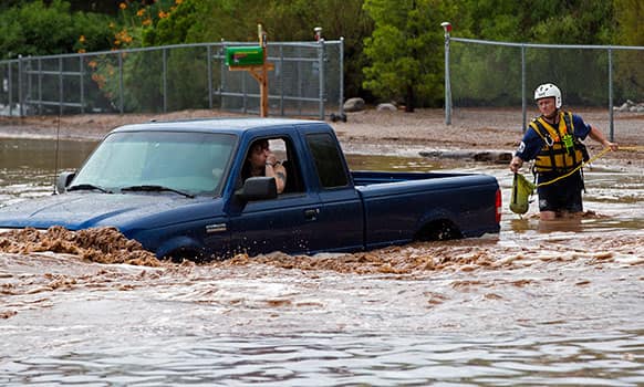 A man an woman sit in a truck on Tomahawk Rd. flooded by rain waters in Apache Junction, Ariz. Mesa Fire Dept. were able to walk the two out safely.