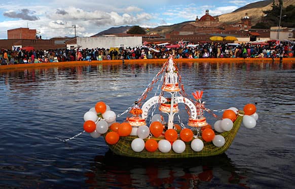 A boat made of reeds that grow in Titicaca Lake crarries cakes on a lagoon during a festival held in honor of Santiago the apostle, known as Saint James in English, the patron saint of the town in Guaqui, Bolivia.