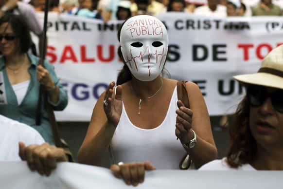 A protestor shouts slogans as she wears a mask reading