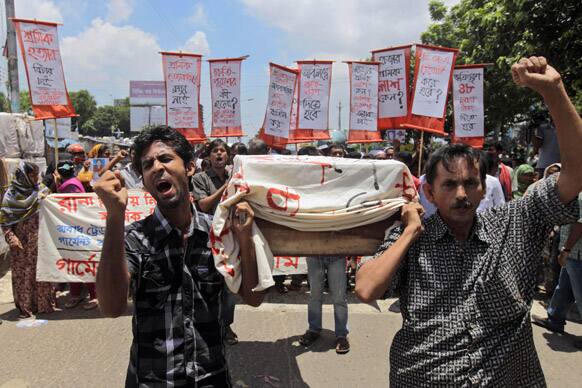 Bangladeshi activists, garment workers and relatives of victims participate in a protest with a symbolic coffin outside the Bangladesh Garment Manufacturers and Export Association (BGMEA) office building in Dhaka, Bangladesh.