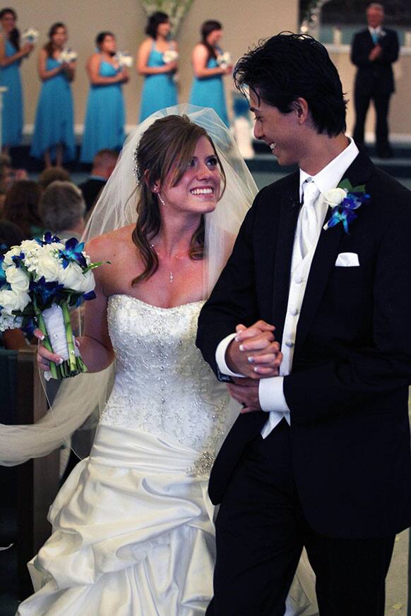 Aurora shooting survivors - and now newlyweds - Eugene and Kirstin Han smile at each other after exchanging vows during their wedding ceremony at Village East Baptist Church, in Aurora, Colorado.