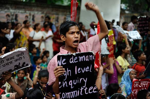 An Indian boy shouts slogans, holding a placards during a protest organized by non-governmental organization Bachpan Bachao Andolan, or Save Childhood Movement, against the death of schoolchildren after eating free midday meal served at a school, in New Delhi.