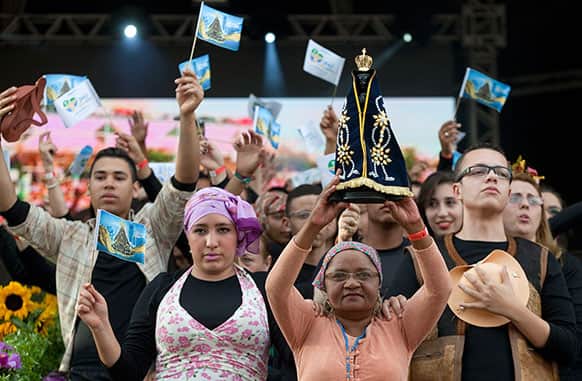 A woman holds up a replica of the statue of Our Lady of Aparecida during a special Catholic Mass ahead of World Youth Day in Sao Paulo, Brazil.