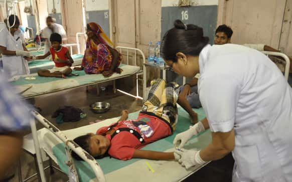 Children who fell ill after eating the daily free lunch at a rural Indian school undergo treatment at a hospital in Patna.