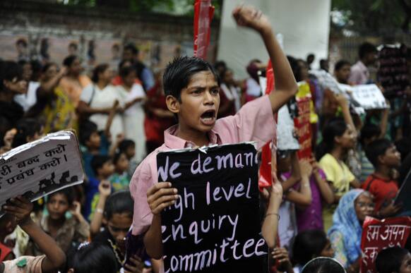 A boy shouts slogans, holding a placards during a protest organized by non-governmental organization Bachpan Bachao Andolan, or Save Childhood Movement, against the death of schoolchildren after eating free midday meal served at a school, in New Delhi.