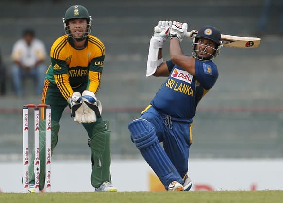 Sri Lanka`s batsman Kumar Sangakkara plays a shot as South Africa`s wicketkeeper AB de Villiers watches during their first One Day International cricket match in Colombo, Sri Lanka.