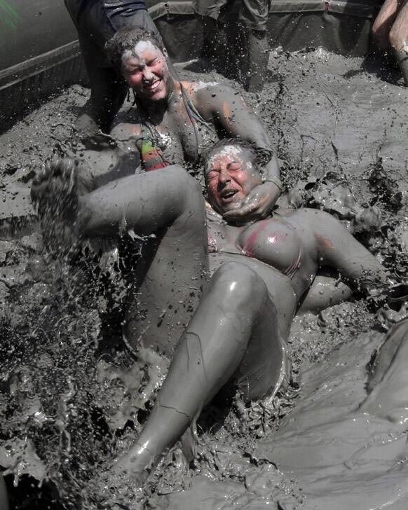 Foreign tourists wrestle in a mud pool during the Boryeong Mud Festival at Daecheon Beach in Boryeong , South Korea. The 16th annual mud festival features mud wrestling and mud sliding.