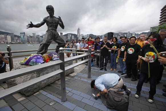 A fan pays tribute to the late Hong Kong Kung Fu star Bruce Lee in front of the bronze statue in Hong Kong to commemorate the 40th anniversary of his death.