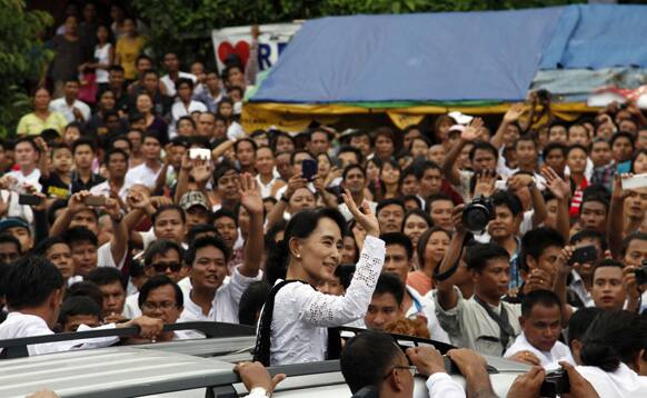 Myanmar opposition leader Aung San Suu Kyi waves to supporters from vehicle after she attended the 66th anniversary of Martyrs Day at the headquarters of her National league for Democracy (NLD) party in Yangon, Myanmar.