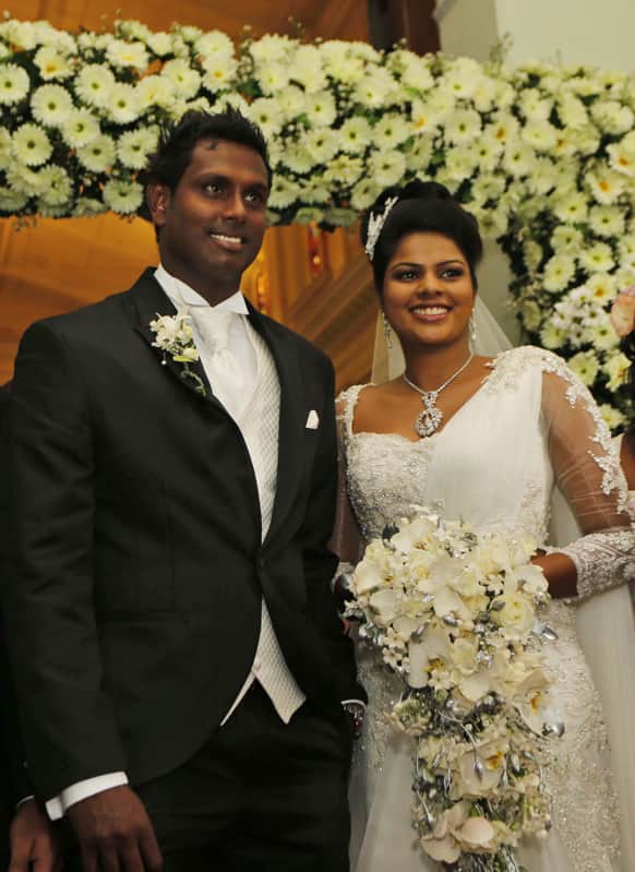Sri Lankan cricket captain Angelo Mathews and his bride Heshani pose for photographs as they come out of a church after their wedding service in Colombo, Sri Lanka.