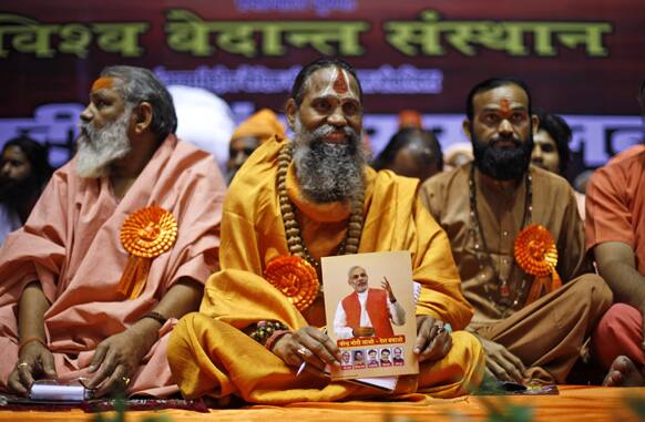 A Sadhu holds a pamphlet displaying a portrait of Gujarat state Chief Minister Narendra Modi during a conference in New Delhi.